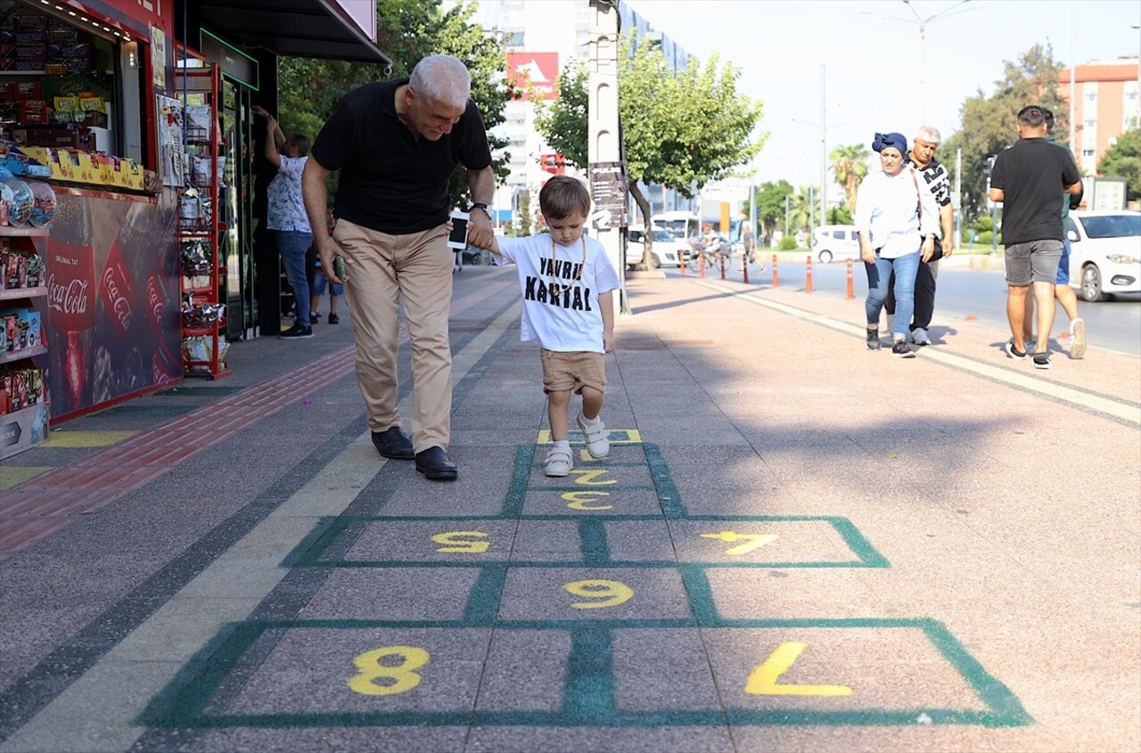 Mersin'de iş yerinin önüne seksek oyunu çizen büfe sahibi, gencini yaşlısını çocukluğuna götürdü....