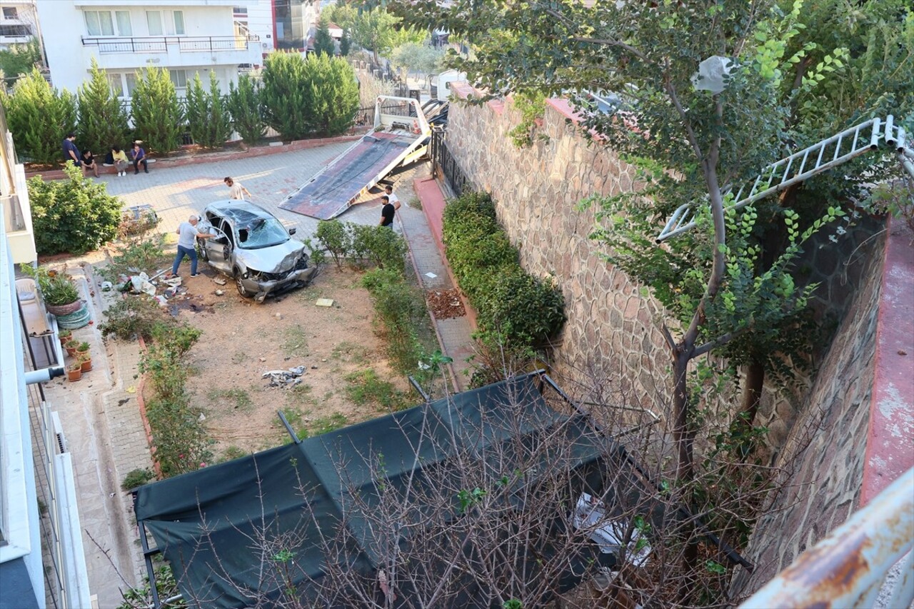 İzmir'in Bornova ilçesinde otomobilin yaklaşık 10 metre yükseklikten apartmanın bahçesine düşmesi...